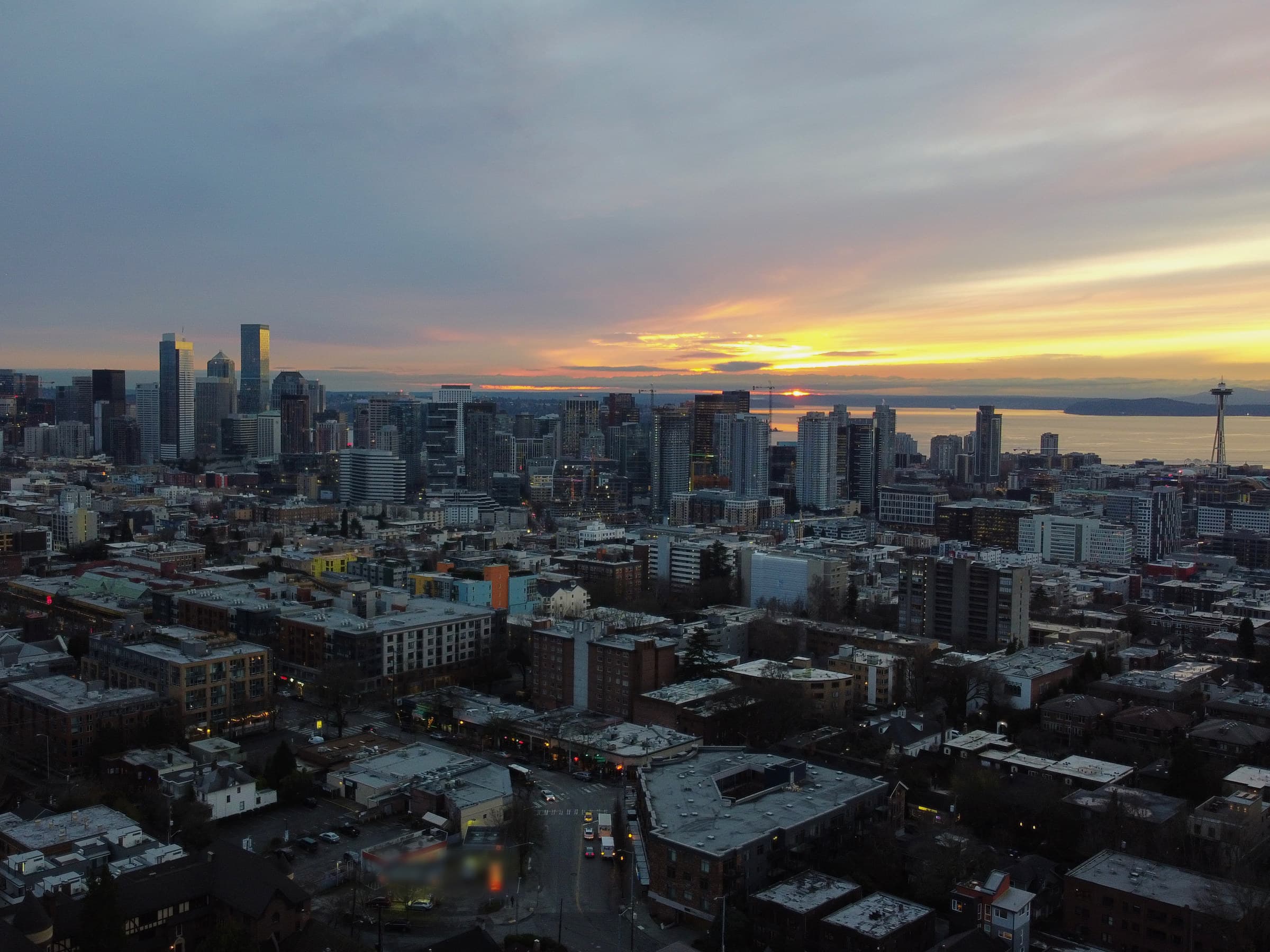 The Seattle skyline and Space Needle at sunset, seen from the air